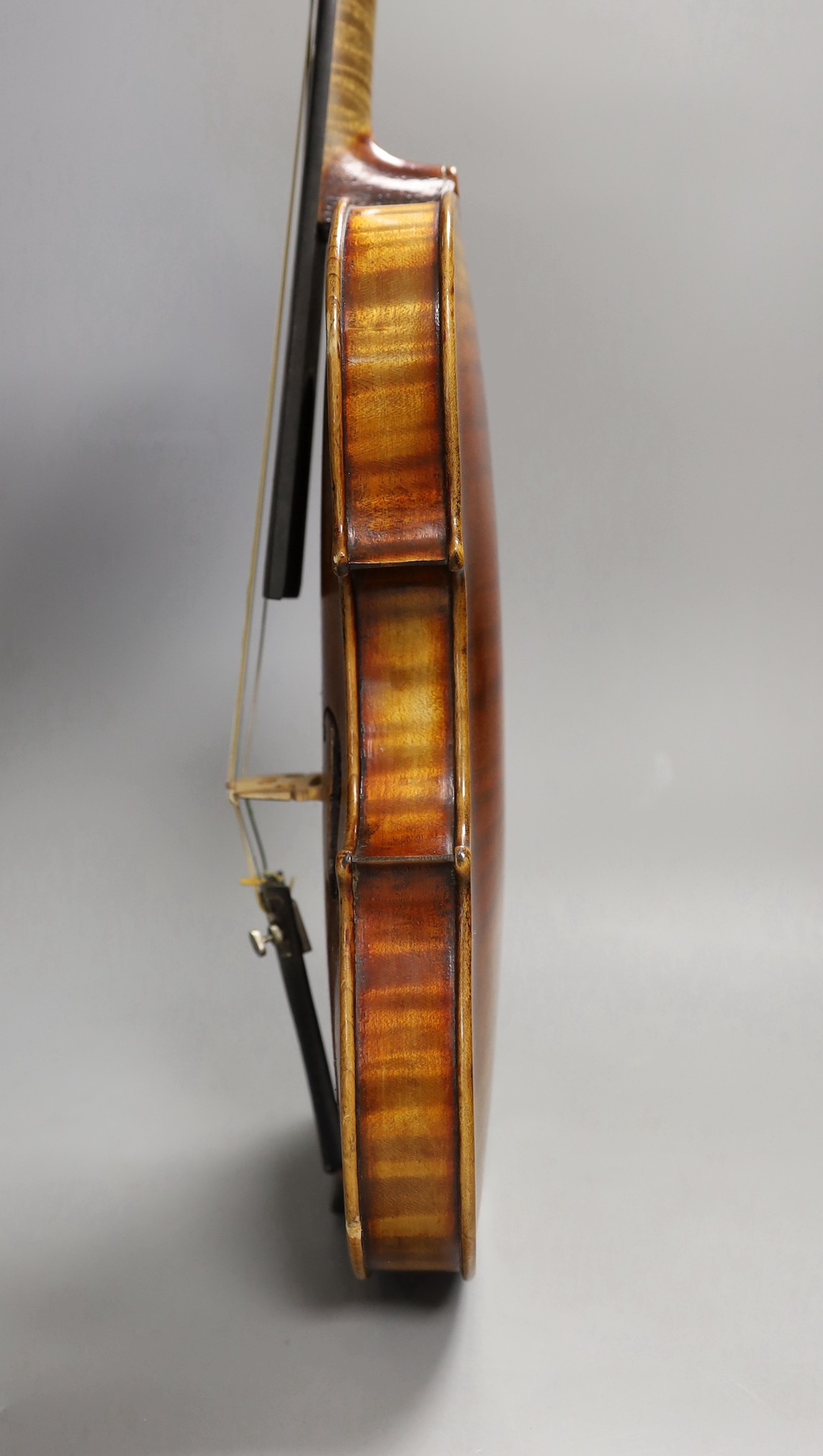 A quarter size late 19th century violin with bow, in E. Hill & Sons case, back measures 29cm